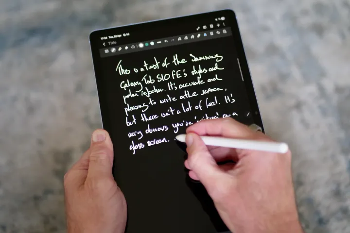 شخص يحمل جهاز Samsung Galaxy Tab S10 FE باستخدام قلم.