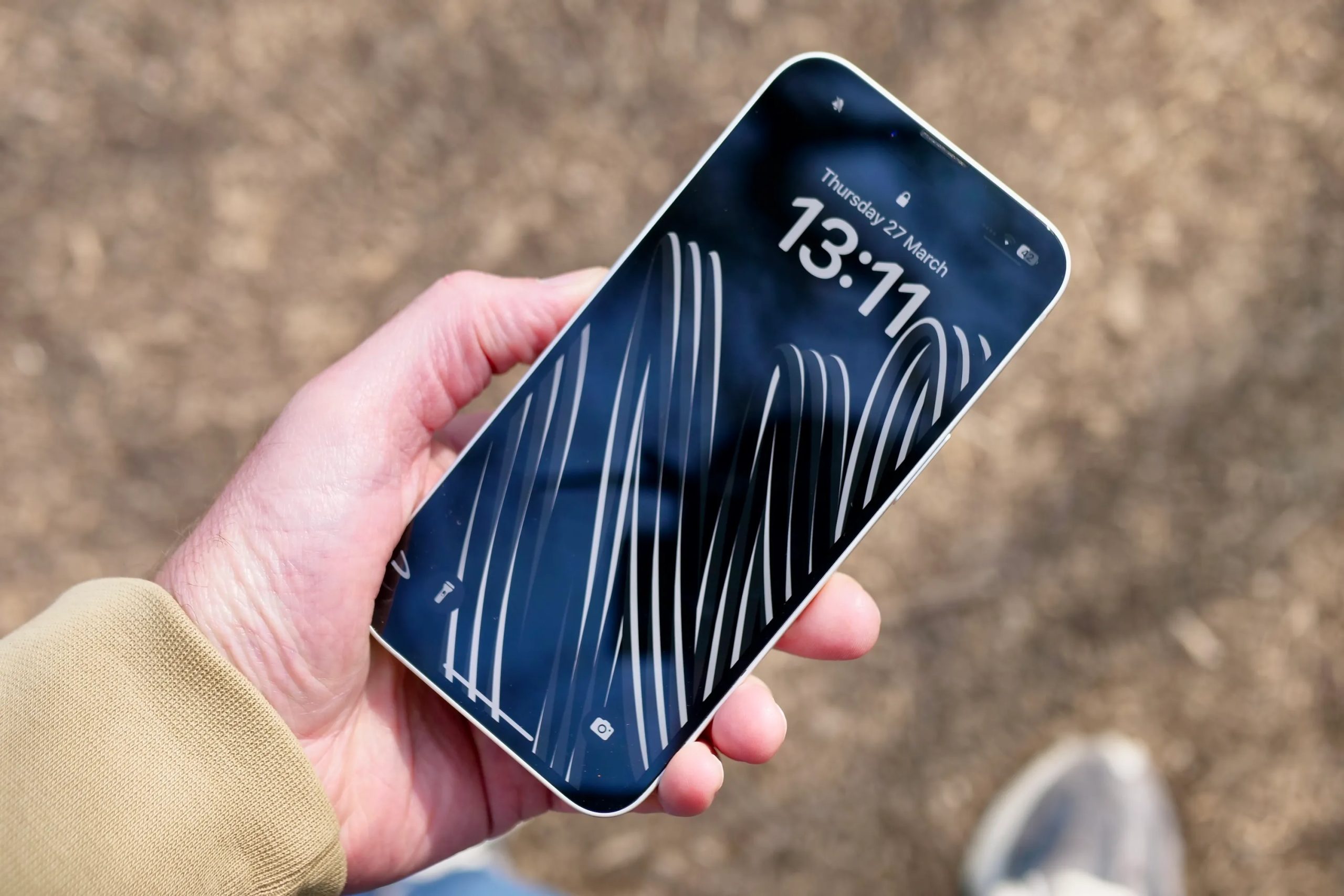 شخص يحمل هاتف Apple iPhone 16e يعرض الشاشة.