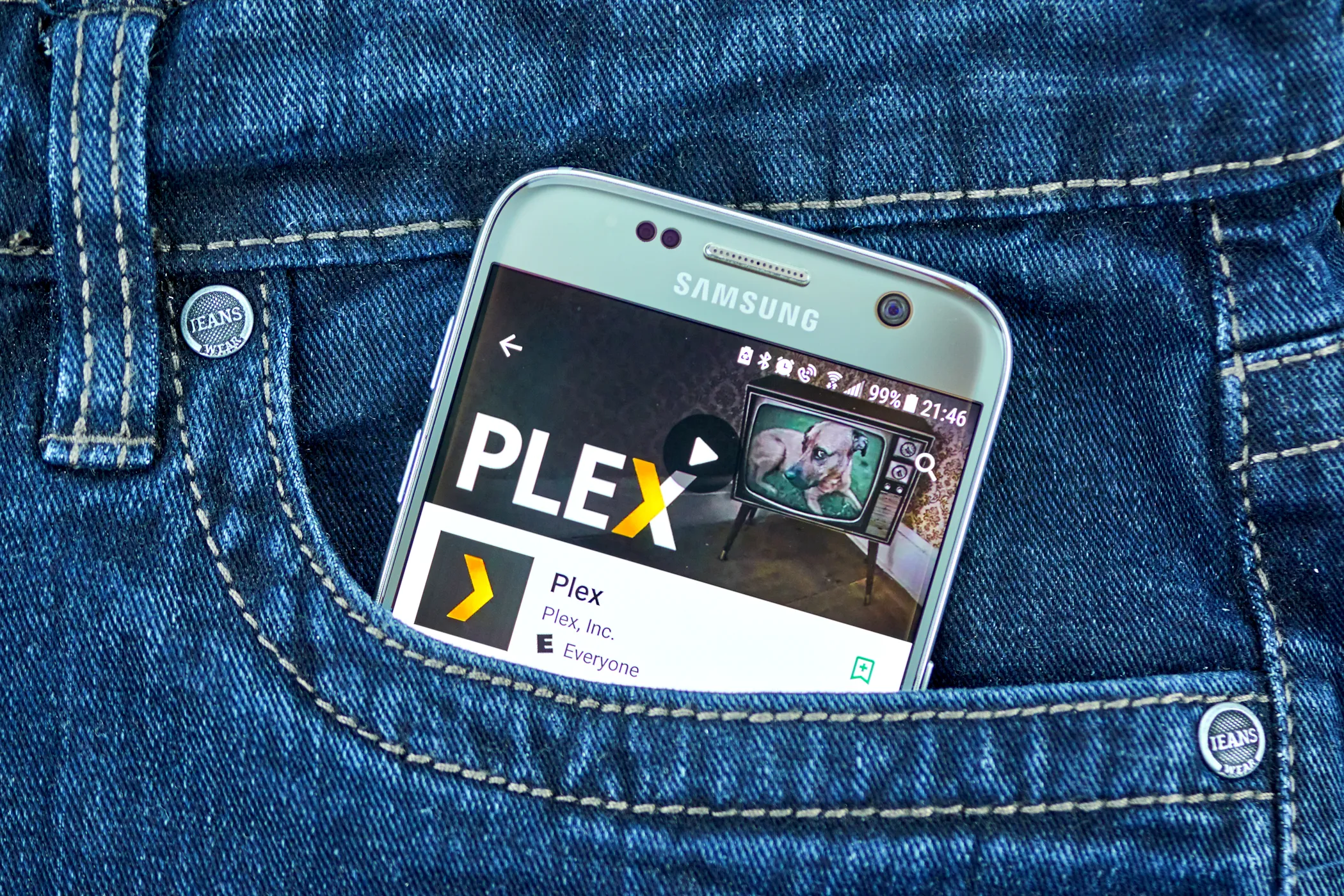 plex on smartphone screen in denim jeans pocket
