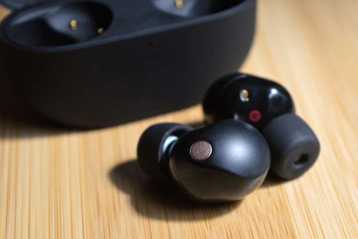 Sony WF-1000XM5 two earbuds sitting in front of charging case.