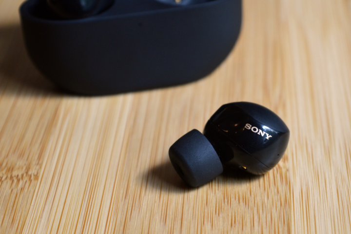 Sony WF-1000XM5 one earbud sitting in front of charging case.