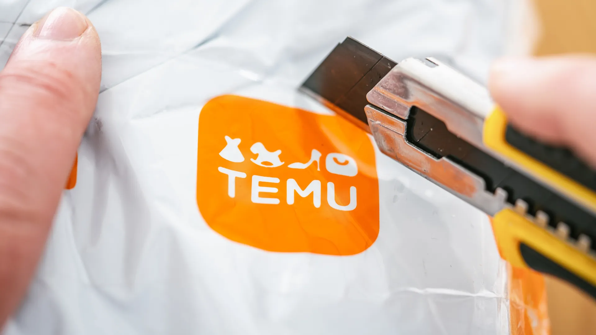 temu logo on plastic bag with blade ready to open.