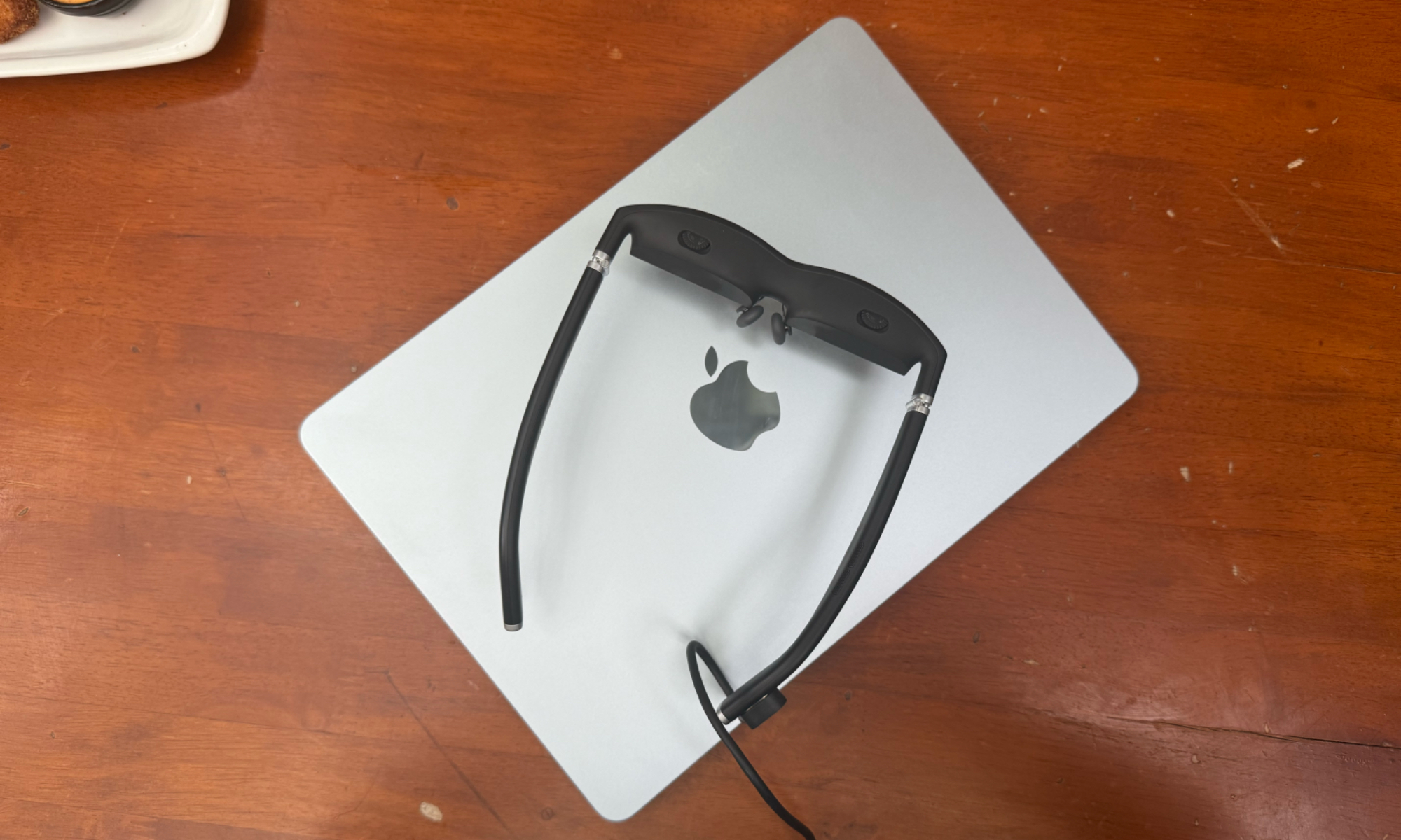 نظارات Viture One الذكية موضوعة على جهاز لابتوب Apple.