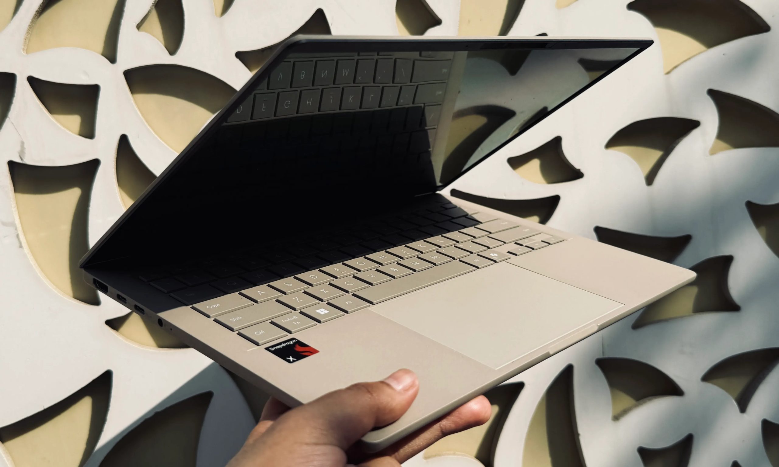 Person holding the Asus ZenBook A14 laptop.