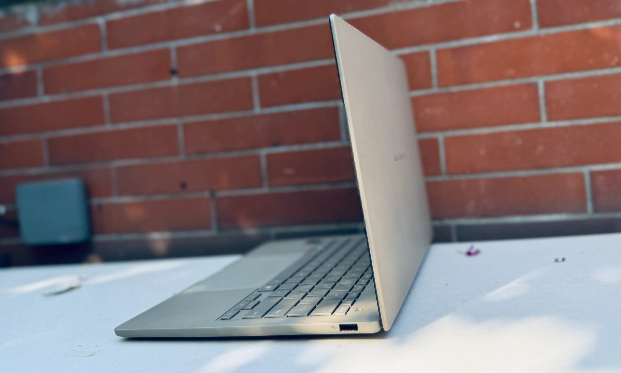 Angled view of Asus ZenBook A14 laptop with lid open.
