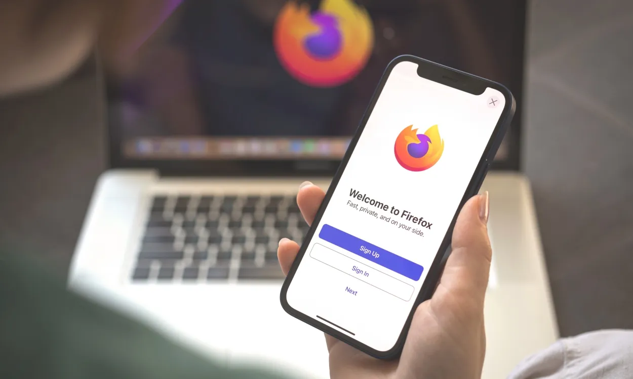 shot of an iPhone with the Mozilla Firefox browser welcome screen in front of a Mac