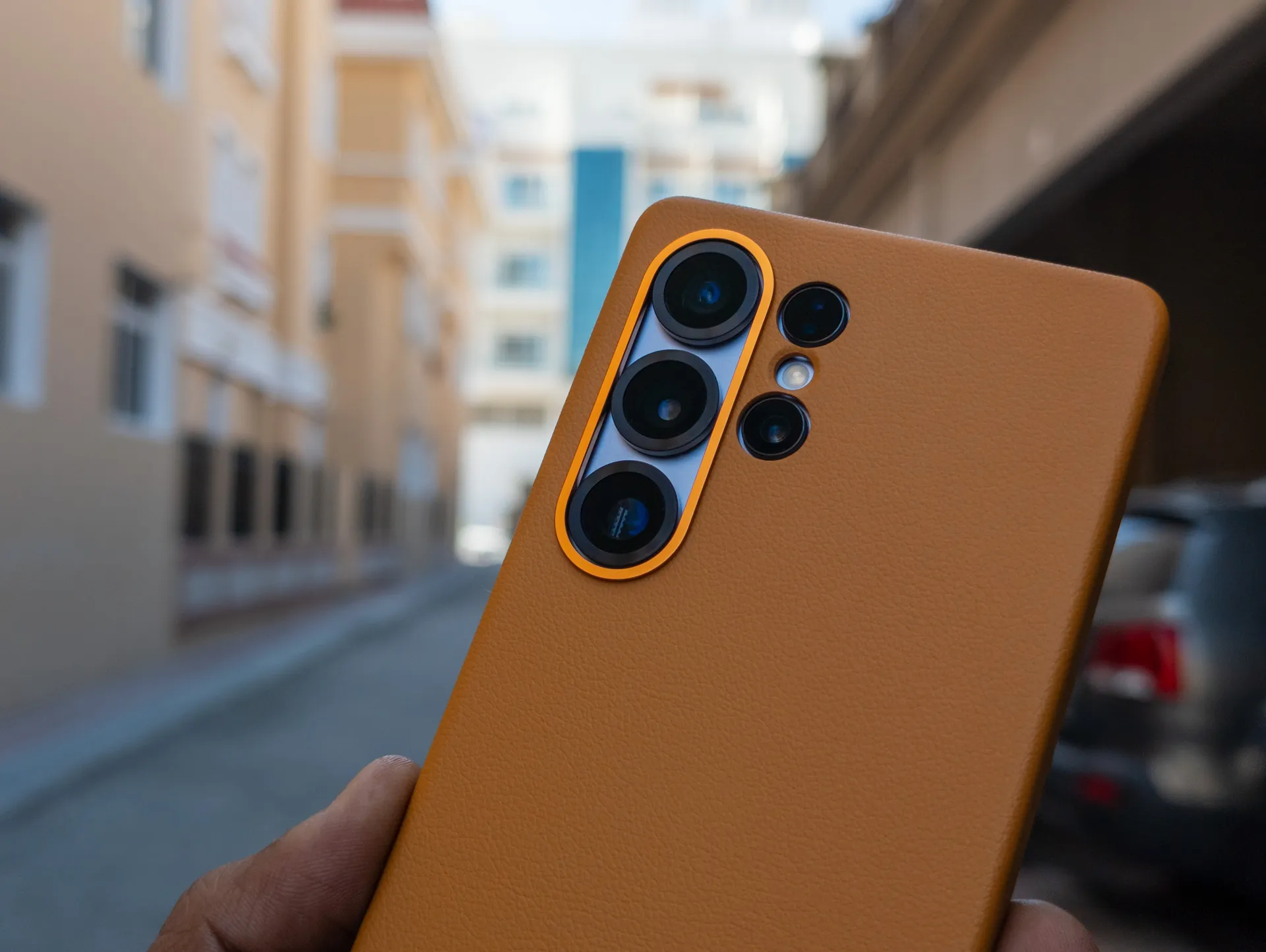 صورة مقربة للكاميرات في هاتف Galaxy S25 Ultra Kindsuit Leather Case باللون الجملي في اليد