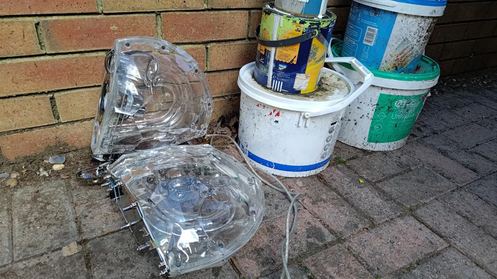 مكبرات صوت الكمبيوتر الشخصي في الخارج بجوار بعض علب الطلاء.