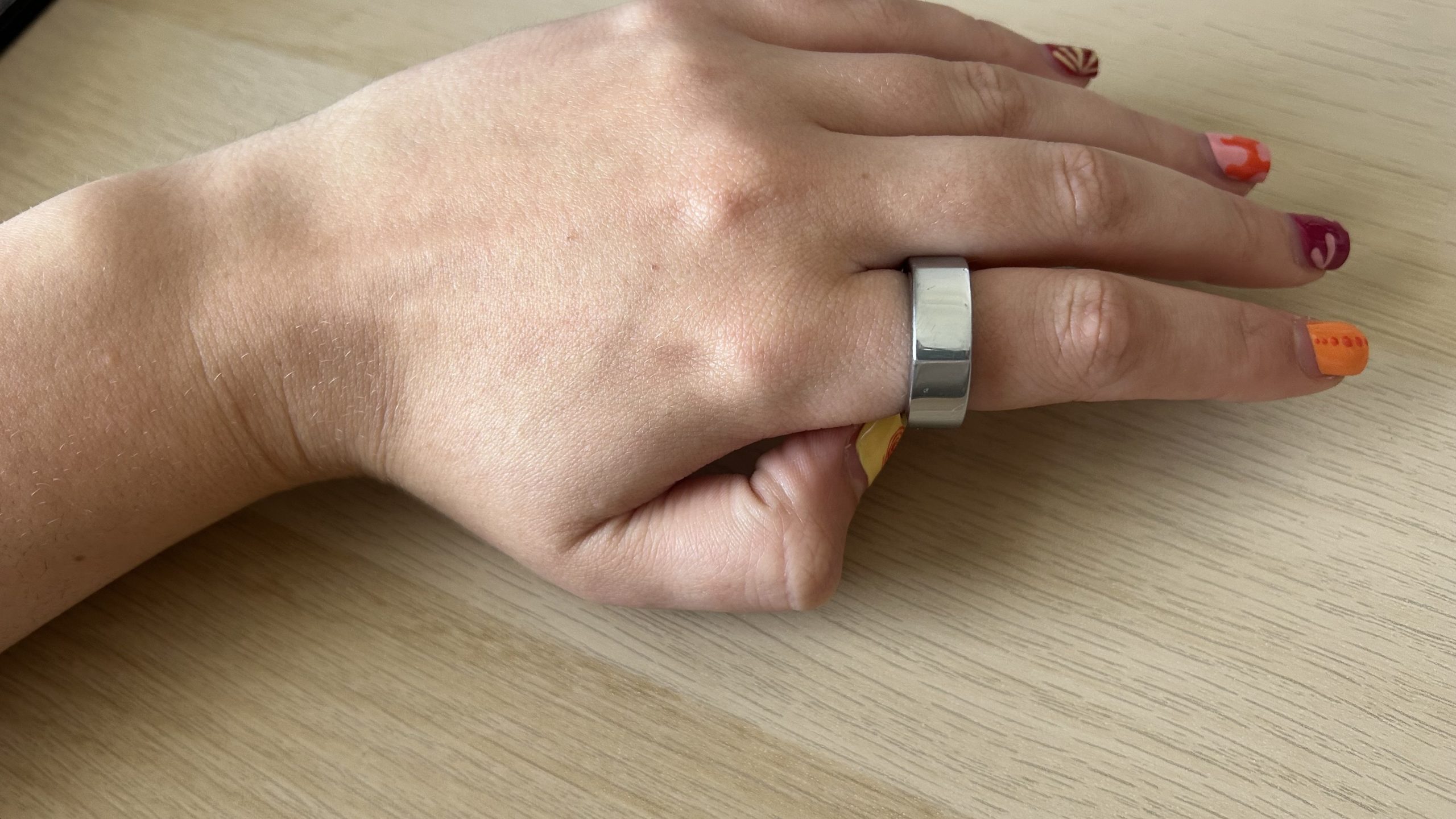Woman's left hand wearing Oura Ring Gen3 on index finger