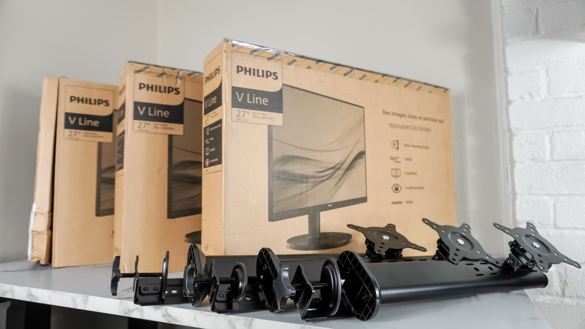 The Philips V8 Series monitors on a desk with three monitor stands next to them