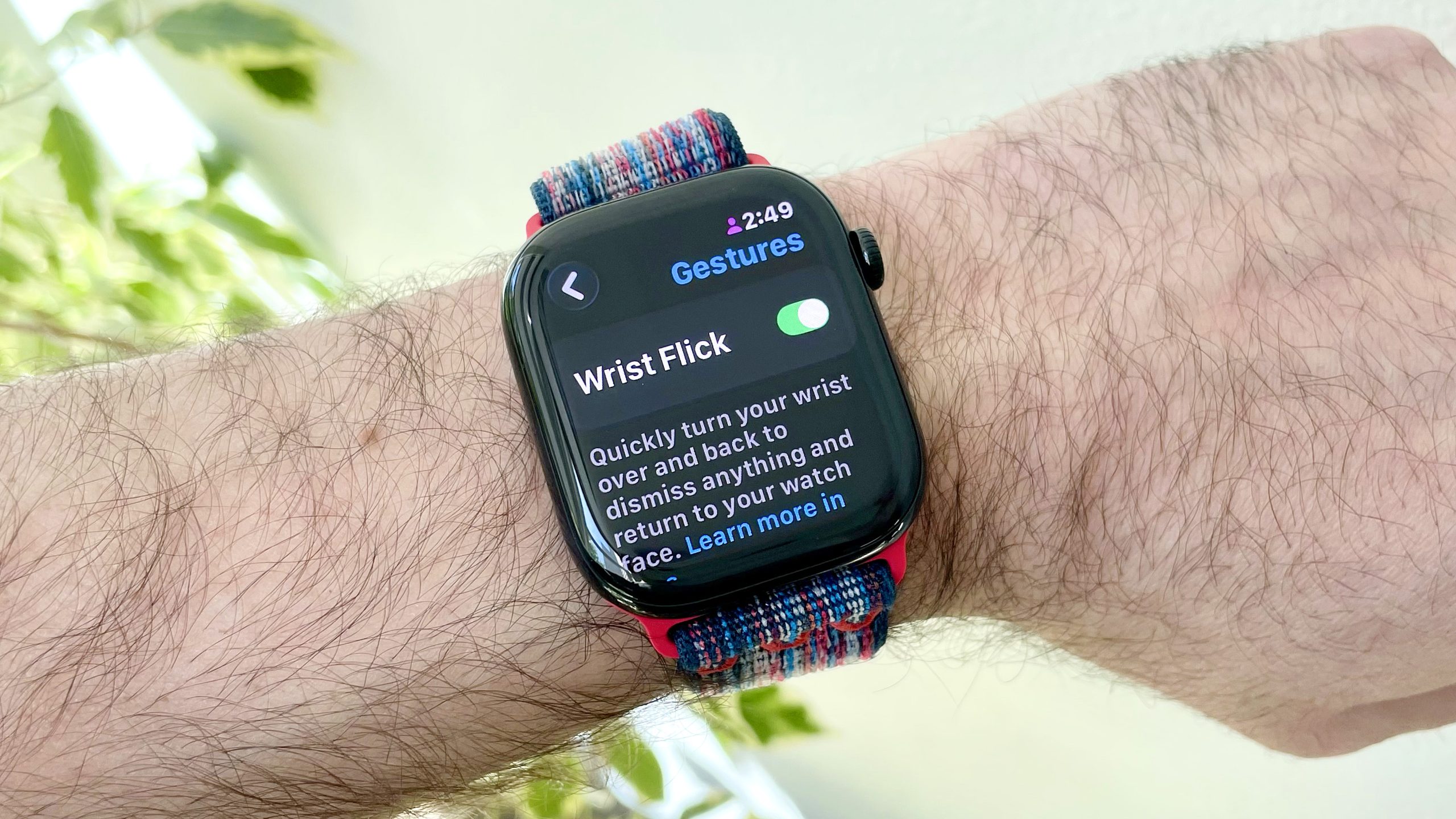 صورة مقربة لساعة Apple Watch 10 على معصم المستخدم تعرض خيار القائمة لتشغيل إيماءة نفضة المعصم الجديدة في watchOS 26