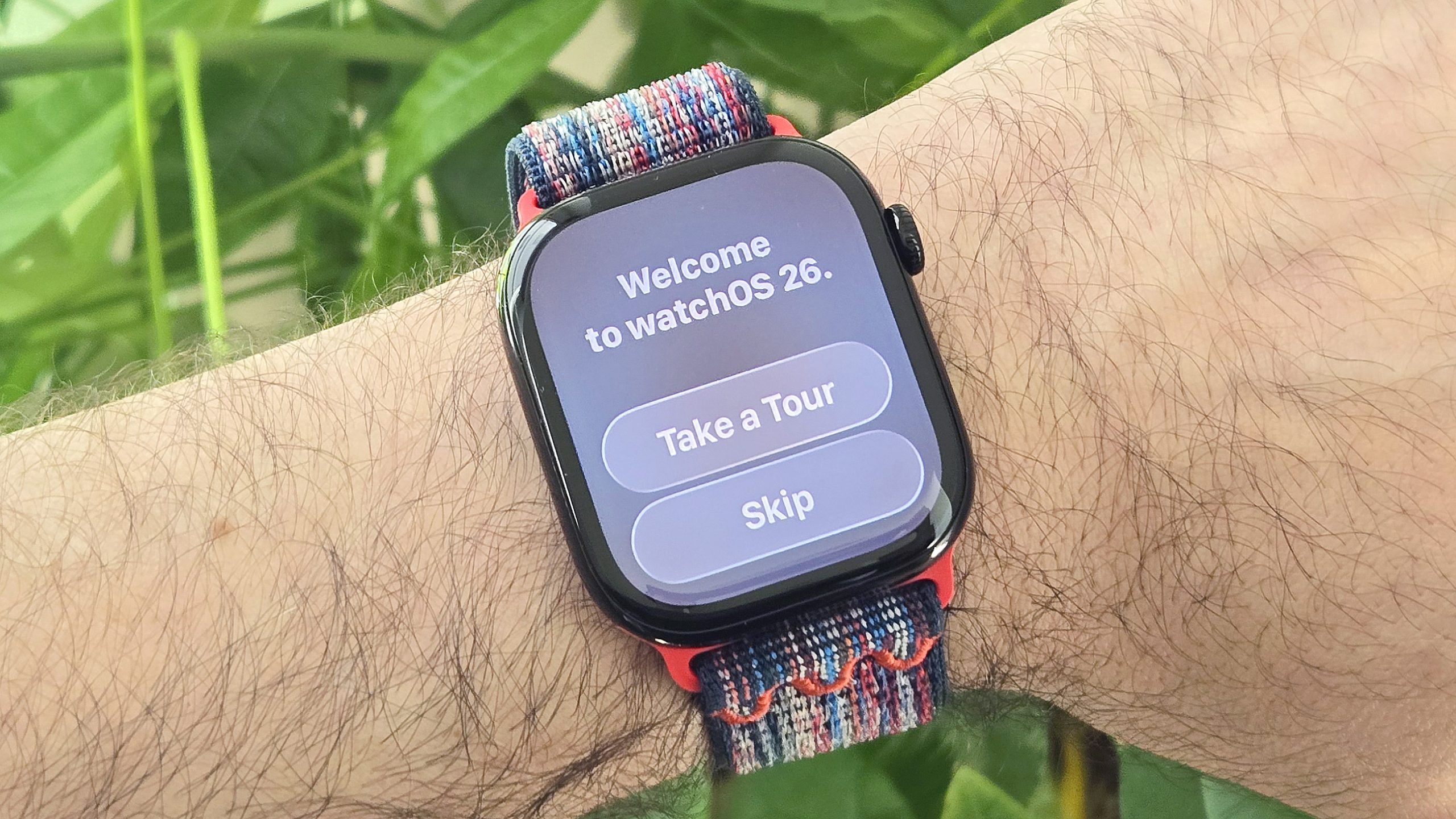 صورة مقربة لساعة Apple Watch Series 10 على معصم المستخدم مع رسالة "Welcome to watchOS 26" معروضة على الشاشة