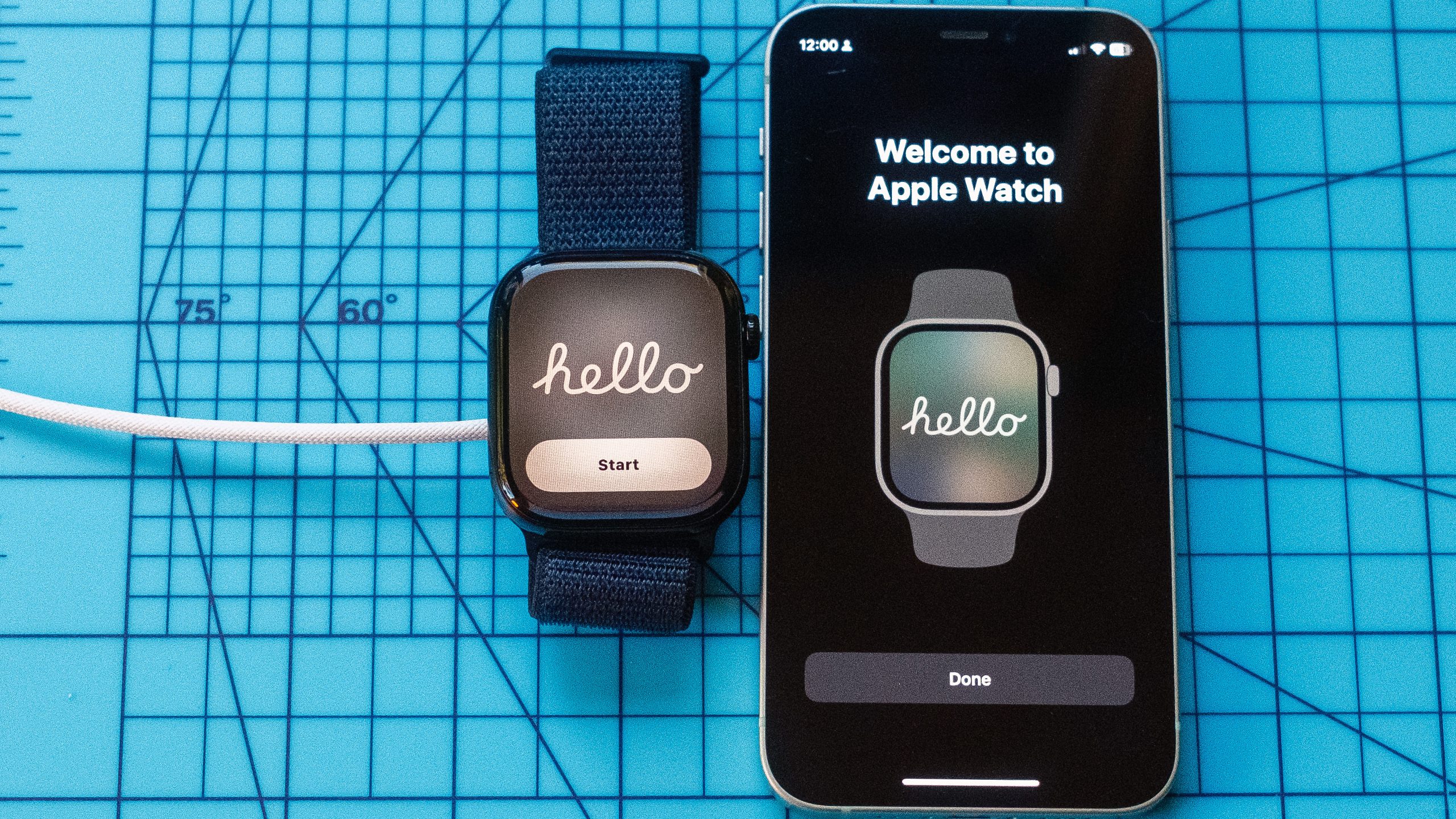 صورة مقربة لساعة Apple Watch 10 تعرض كلمة "Hello" بجوار iPhone يعرض الرسالة نفسها. كلاهما موضوعان على حصيرة زرقاء فاتحة