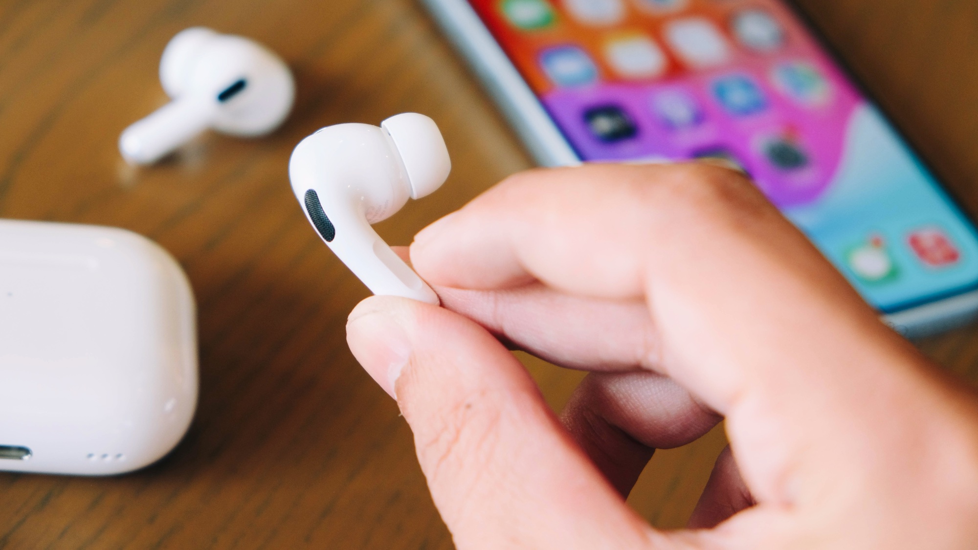 AirPods Pro 2 في اليد أمام iPhone