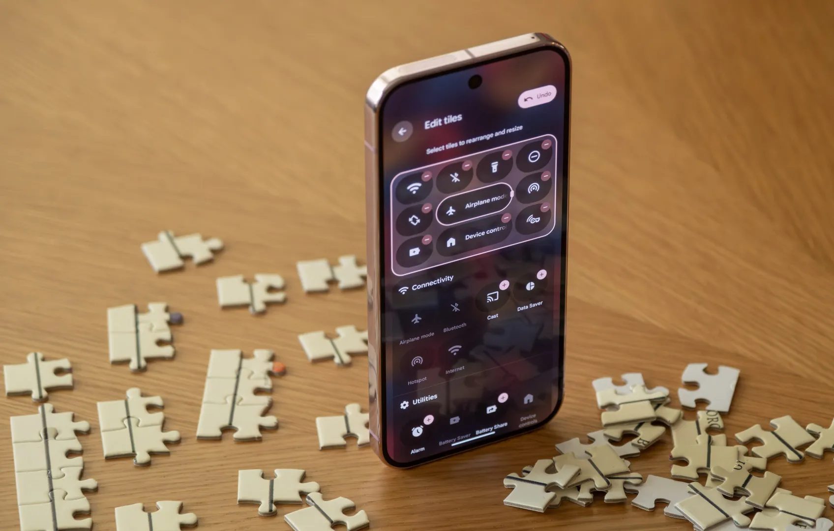 هاتف Pixel 9 Pro مفتوح على الإعدادات السريعة، موضوع بشكل مستقيم بين قطع أحجية.