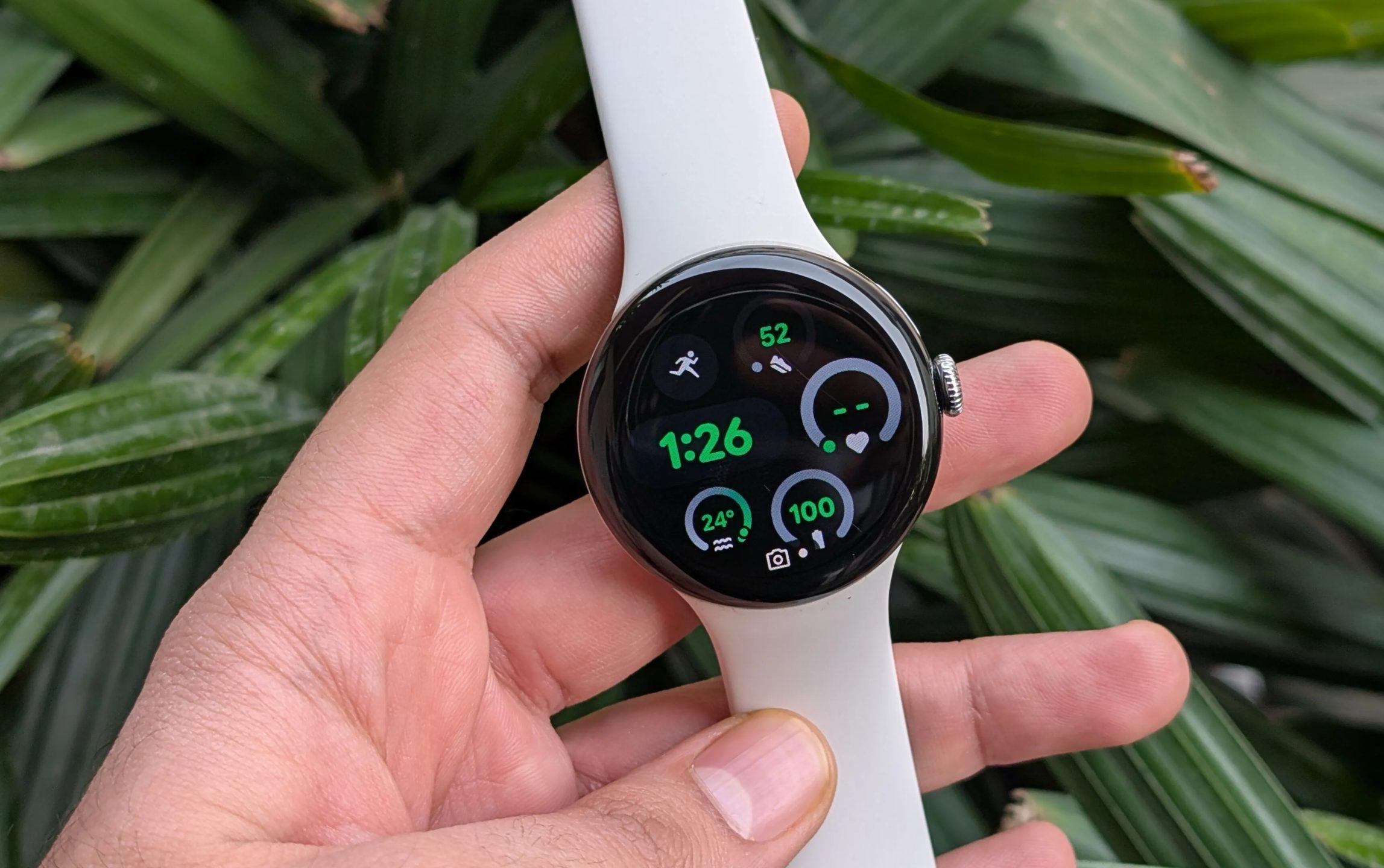 Google Pixel Watch 3 in hand in front of green plants