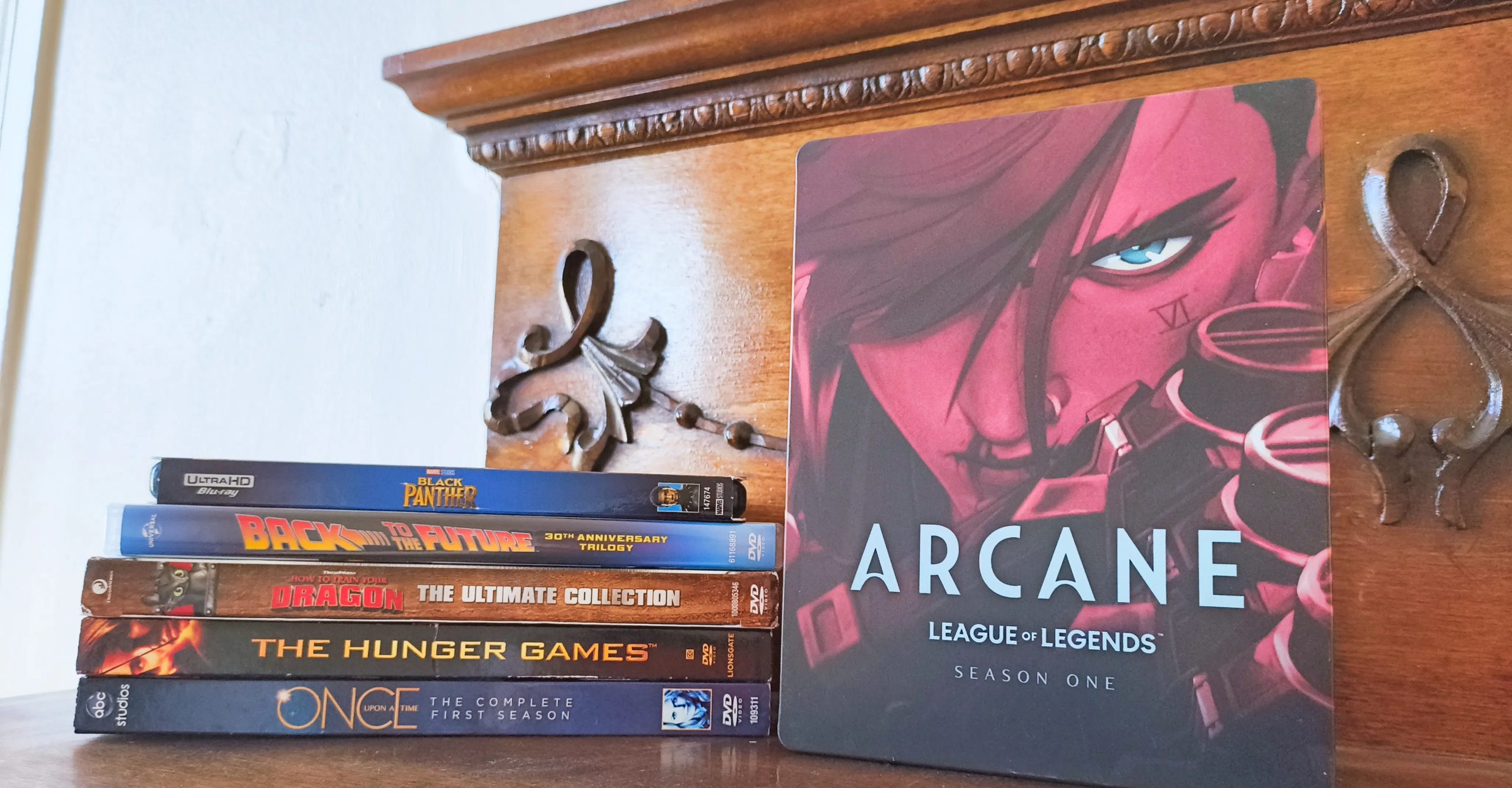 نسخة خاصة من الموسم الأول من مسلسل Arcane على Blu-Ray بجوار مجموعة من أقراص DVD و Blu-Ray