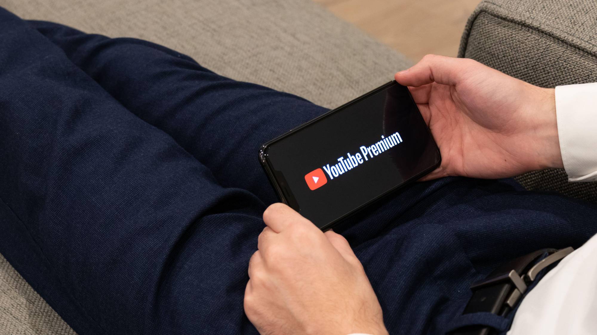 شعار YouTube Premium على هاتف ذكي محمول بين يدي شخصين
