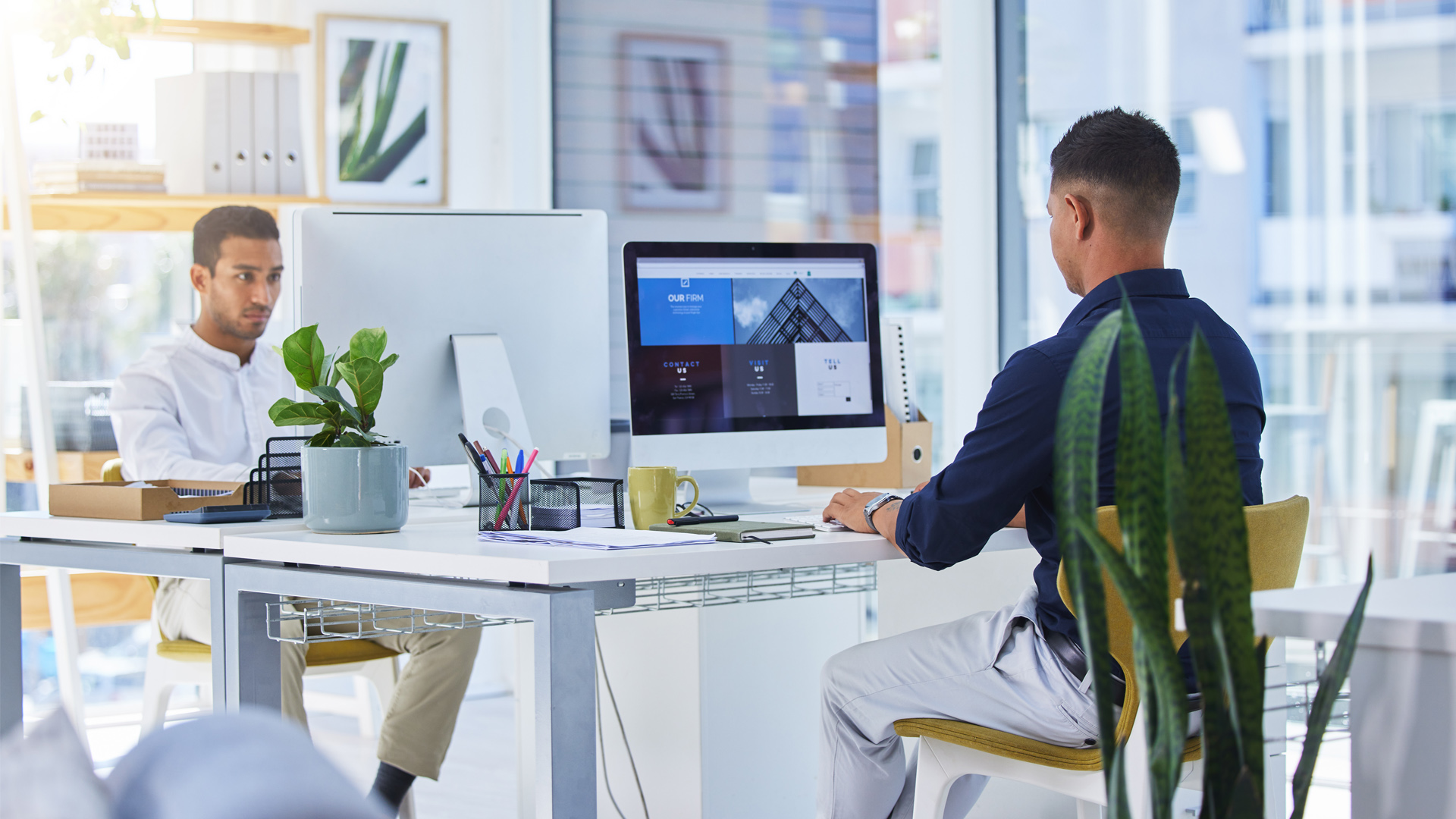 رجلان يعملان على أجهزة الكمبيوتر في المكتب