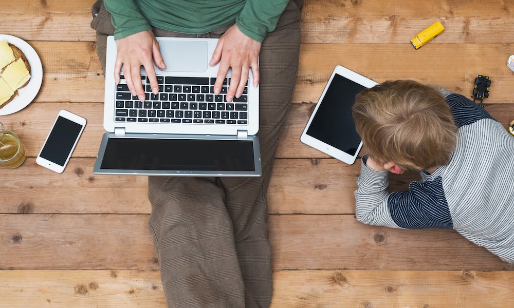 أم وابنها يستخدمان جهاز لوحي وحاسوب محمول