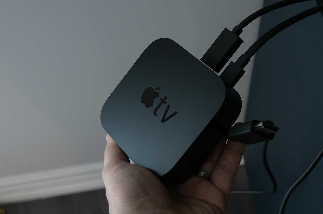 يد تحمل جهاز Apple TV 4K.