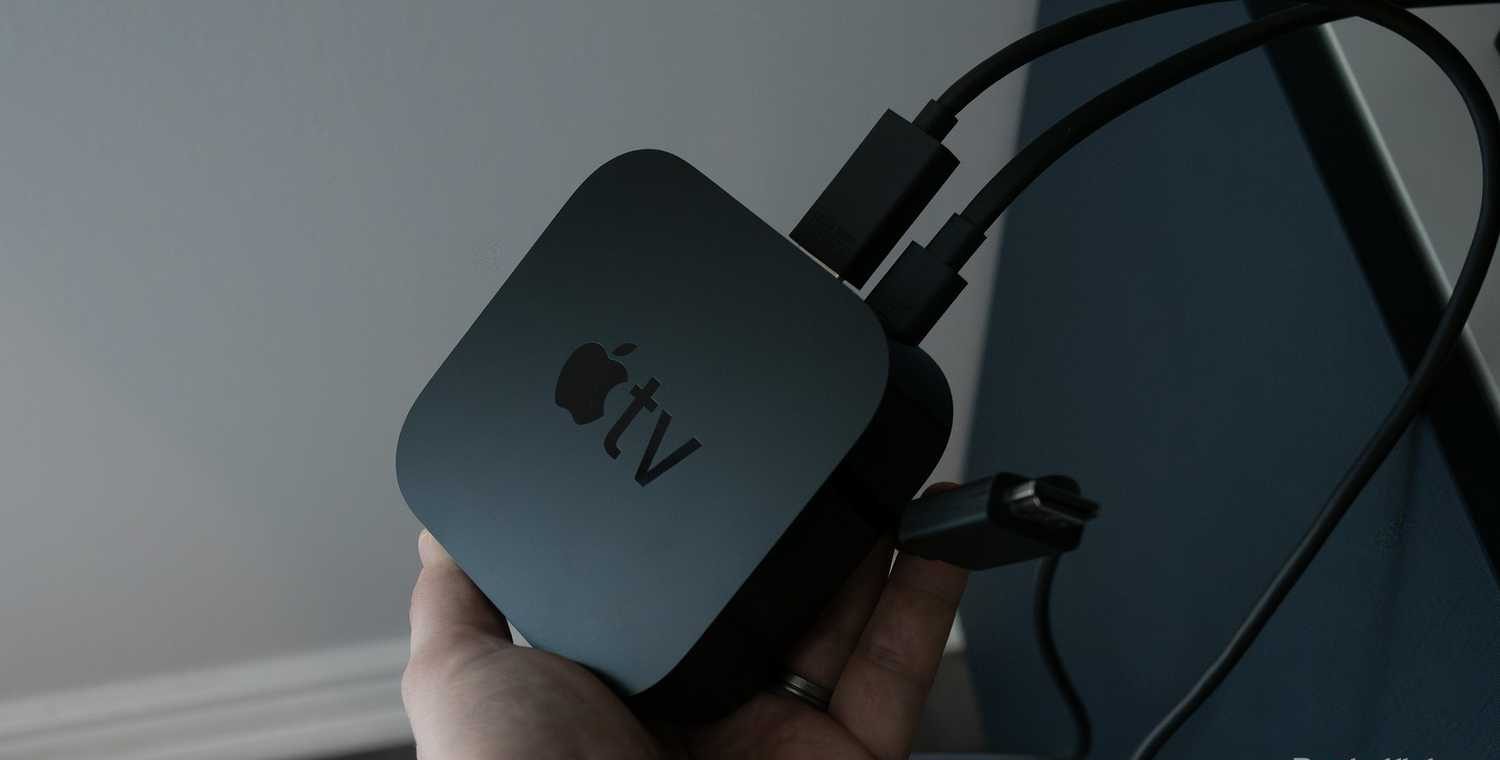 يد تحمل جهاز Apple TV 4K.