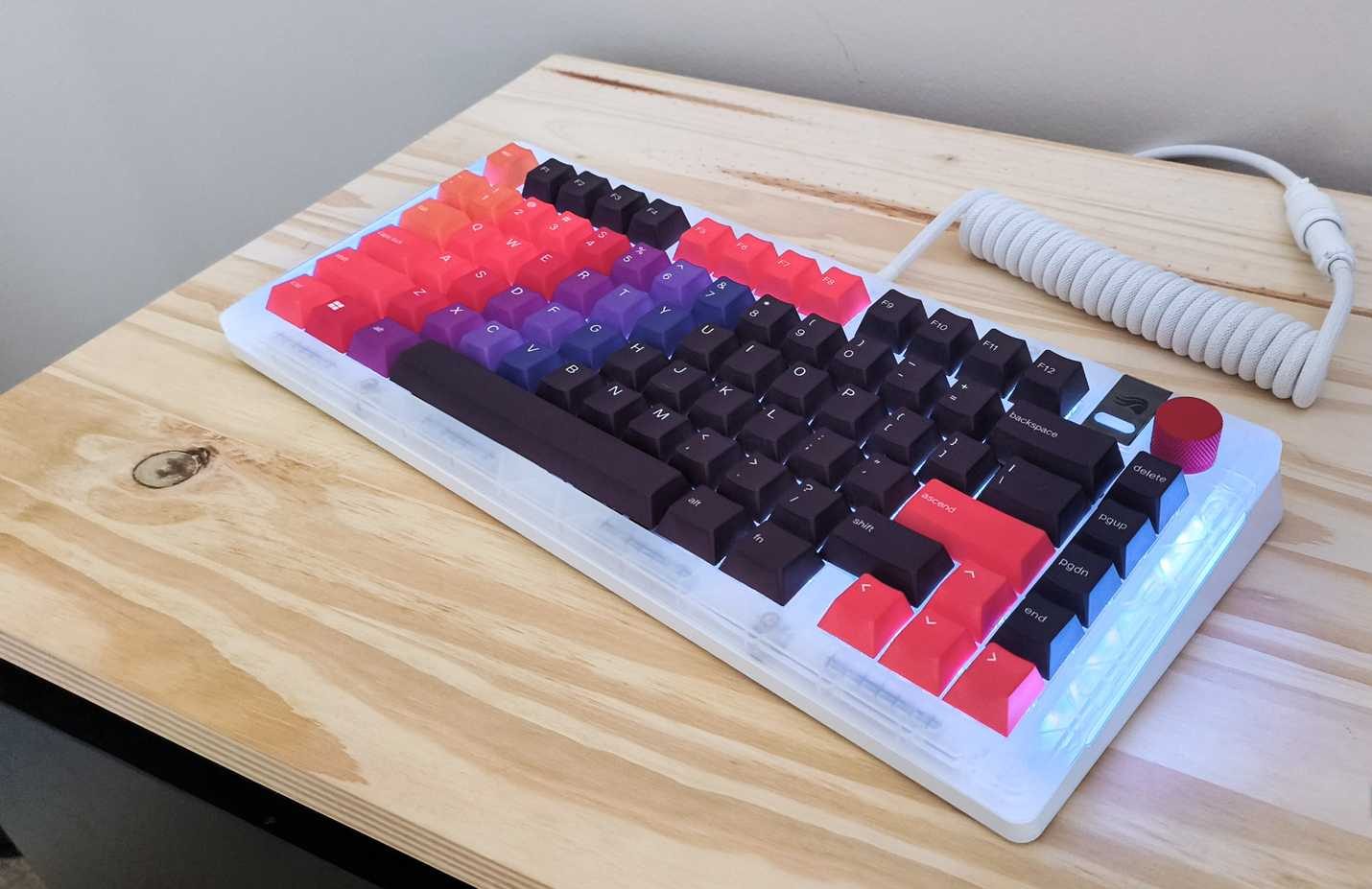 صورة للوحة مفاتيح Glorious Gaming GMMK 3 على طاولة خشبية مع أغطية مفاتيح مخصصة ومقبض وهيكل علوي