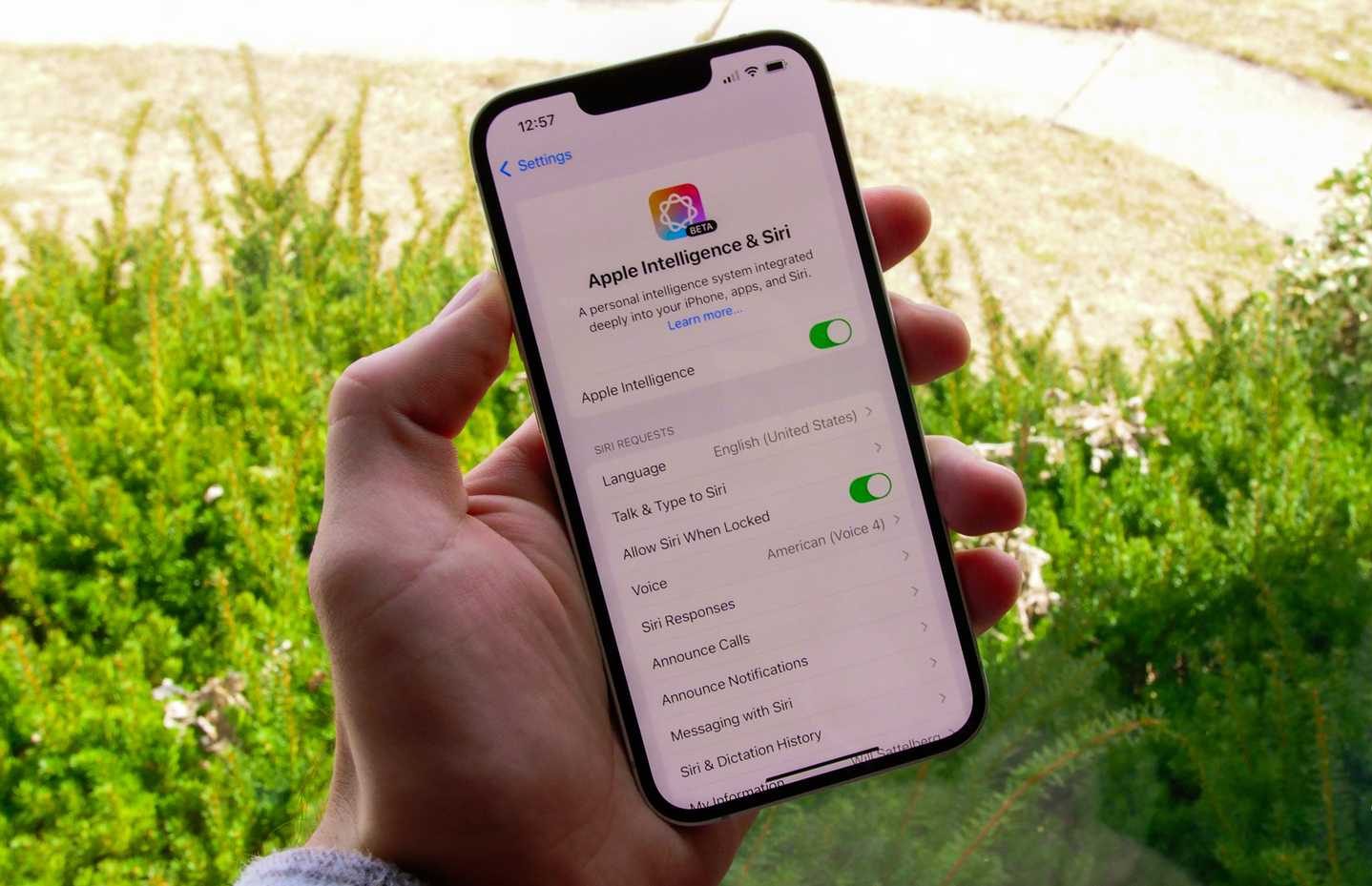 The iPhone 16e in a hand showing the Apple Intelligence menu