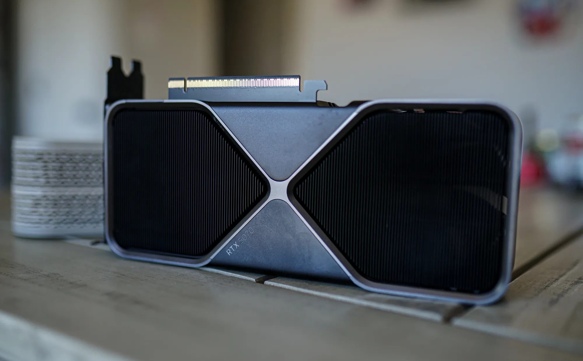 بطاقة رسومات RTX 5070 موضوعة على طاولة والمراوح متجهة للخارج.
