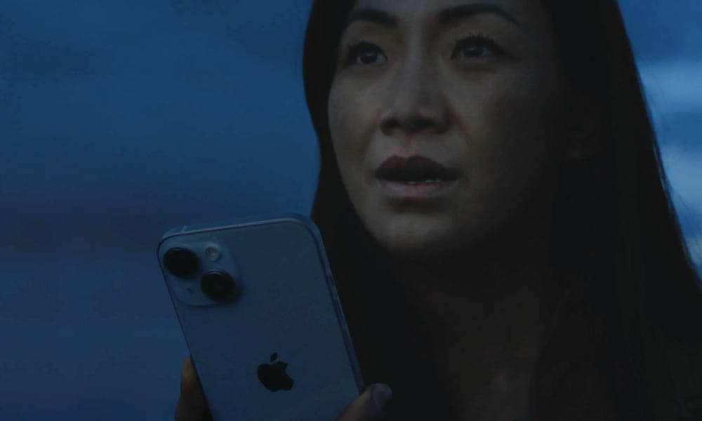 امرأة تحمل هاتف iPhone وتنتظر الإنقاذ عبر الأقمار الصناعية