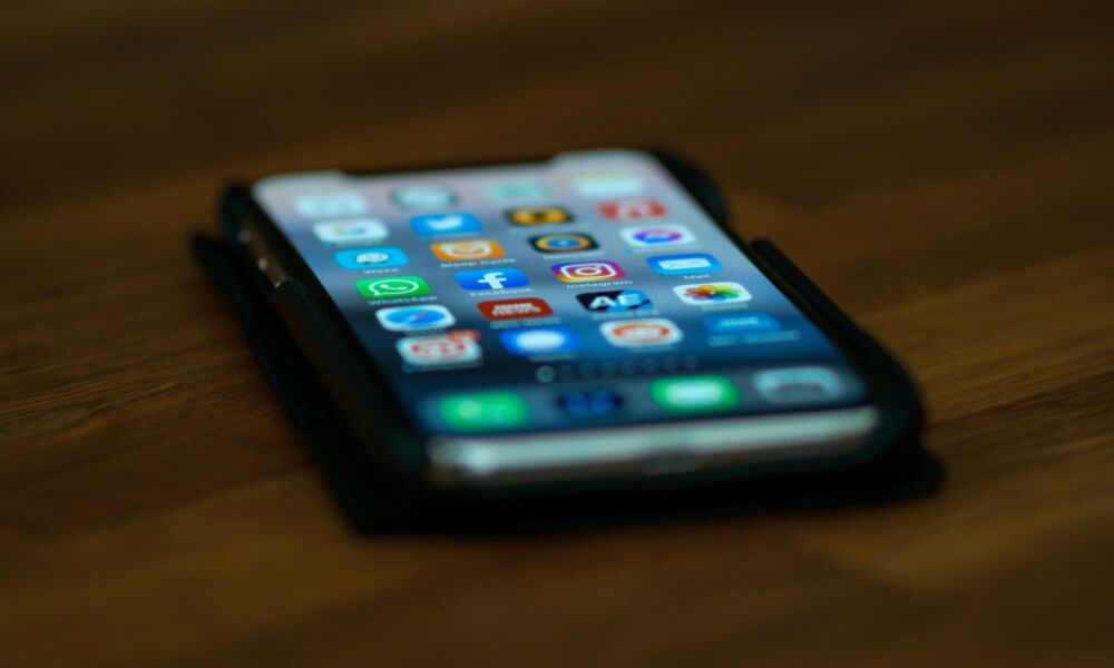 شاشة iPhone على الطاولة مع خلفية ضبابية للتطبيقات