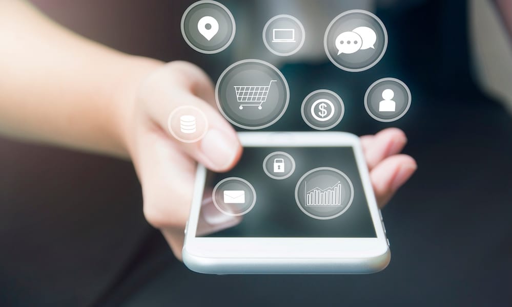 يد سيدة أعمال تلمس هاتفًا ذكيًا مع أيقونات منبثقة تطفو على الهاتف الخلوي بعد ربط عالم الأعمال والتطبيقات في مفهوم الأعمال والتكنولوجيا والمالية والاتصالات