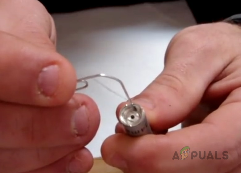 استخدم مشبك ورق لرفع الدبوس المركزي للقلم