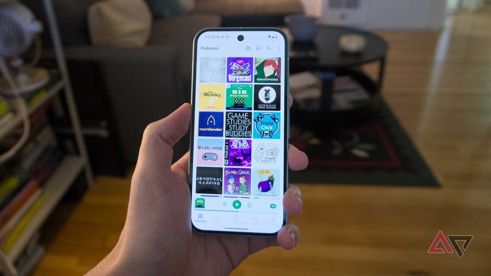A hand holding a Pixel 9 running the Pocket Casts app.