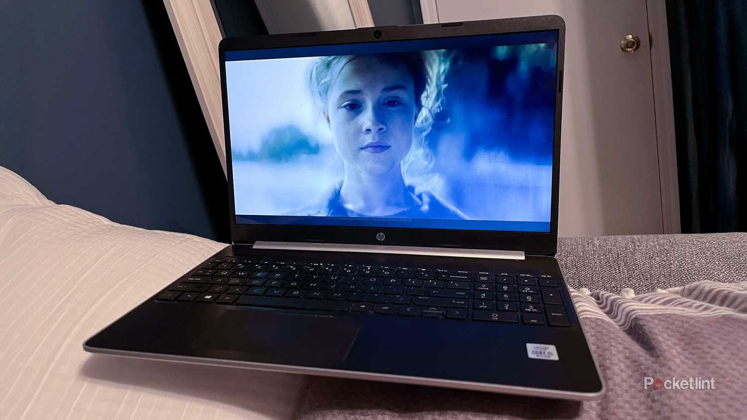 جهاز كمبيوتر محمول قديم موضوع على سرير.