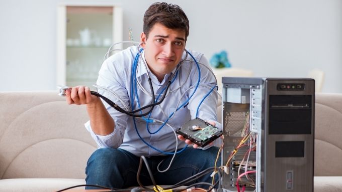 Человек разбирает компьютер.