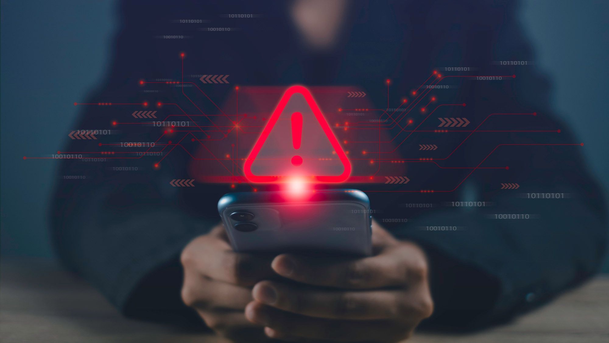 شخص ينظر إلى هاتف مع علامة تحذير رقمية عليه