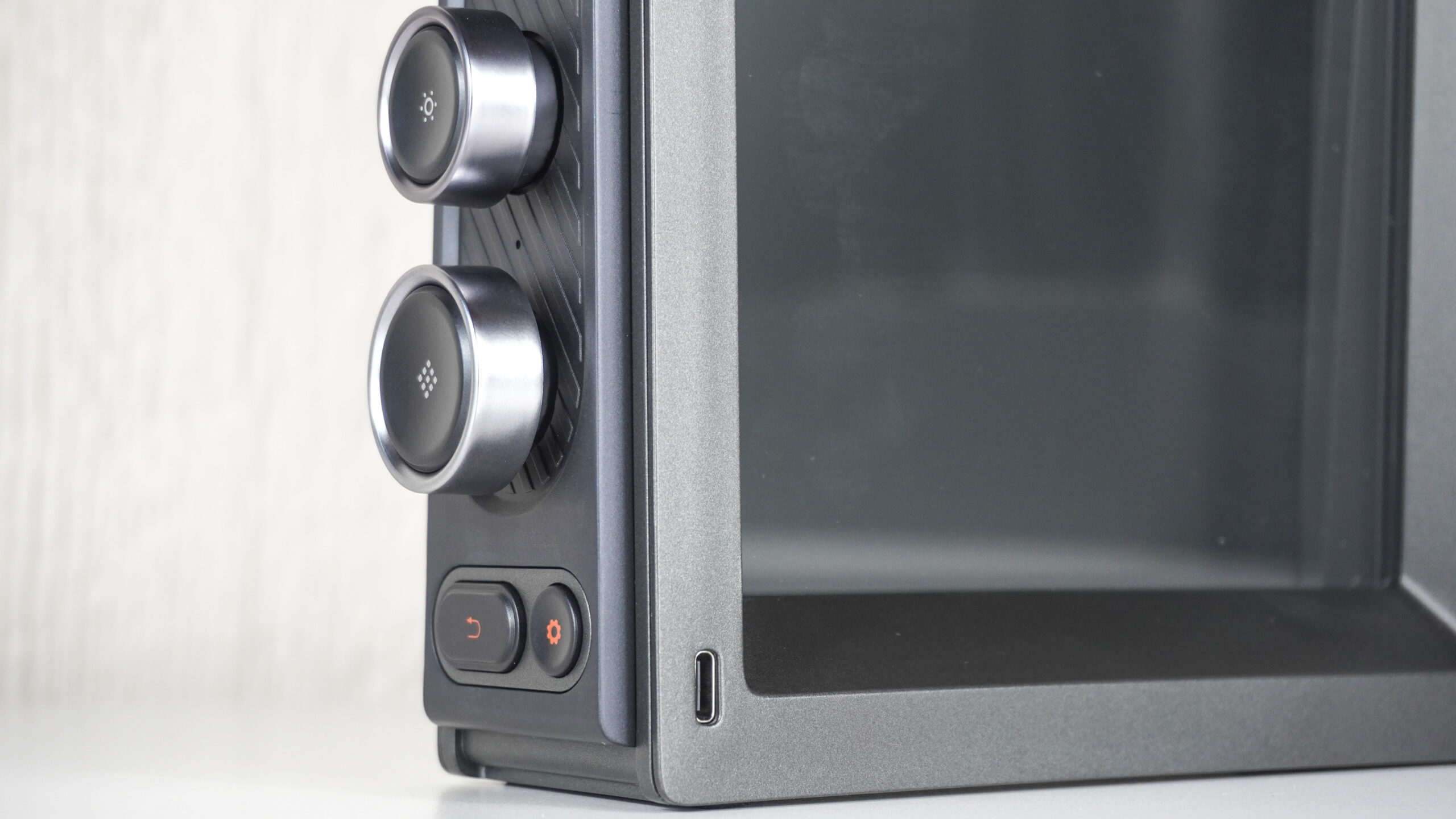 لقطة مقربة تظهر المقابض والأزرار المستخدمة للتحكم في Divoom Times Frame ومنفذ الطاقة USB-C الخاص به