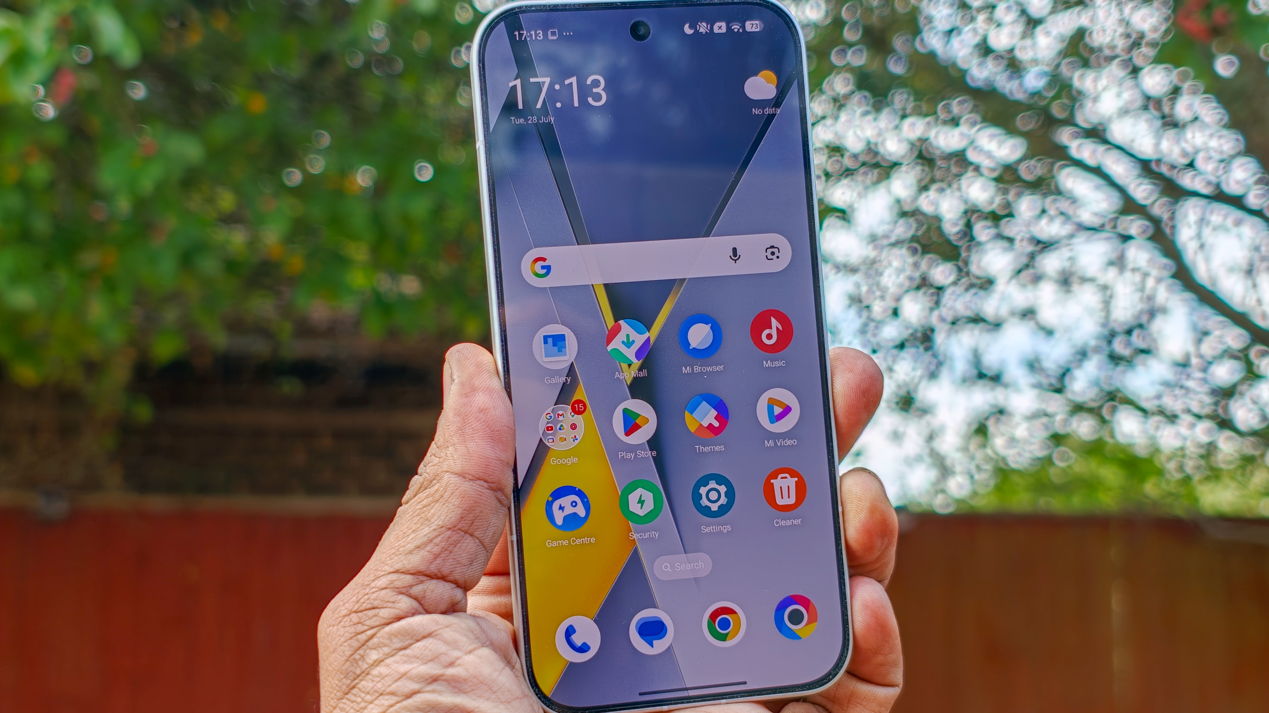 هاتف Poco F8 Pro باللون الفضي في اليد بخلفية حديقة