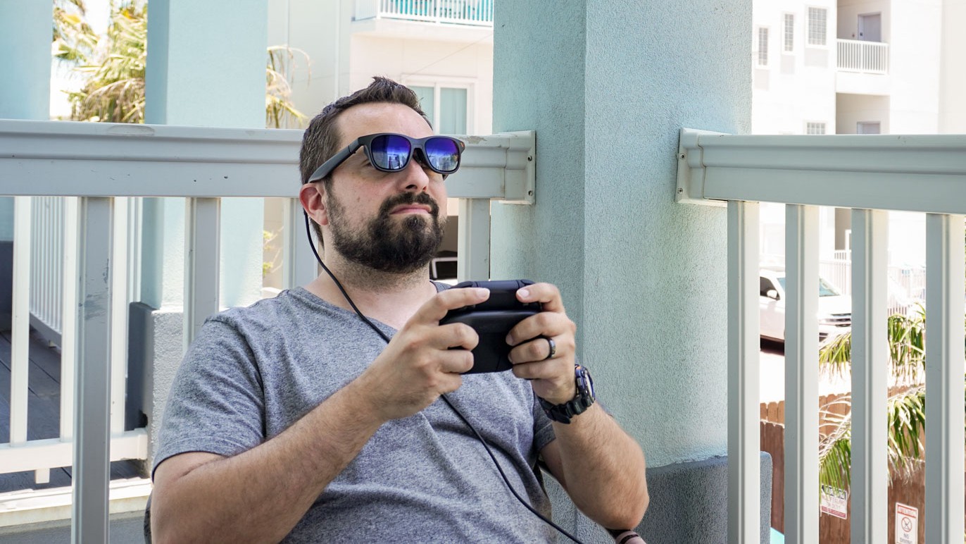 شخص يلعب Switch 2 وهو يرتدي نظارات الواقع المعزز بفضل قاعدة Viture Pro Mobile Dock.