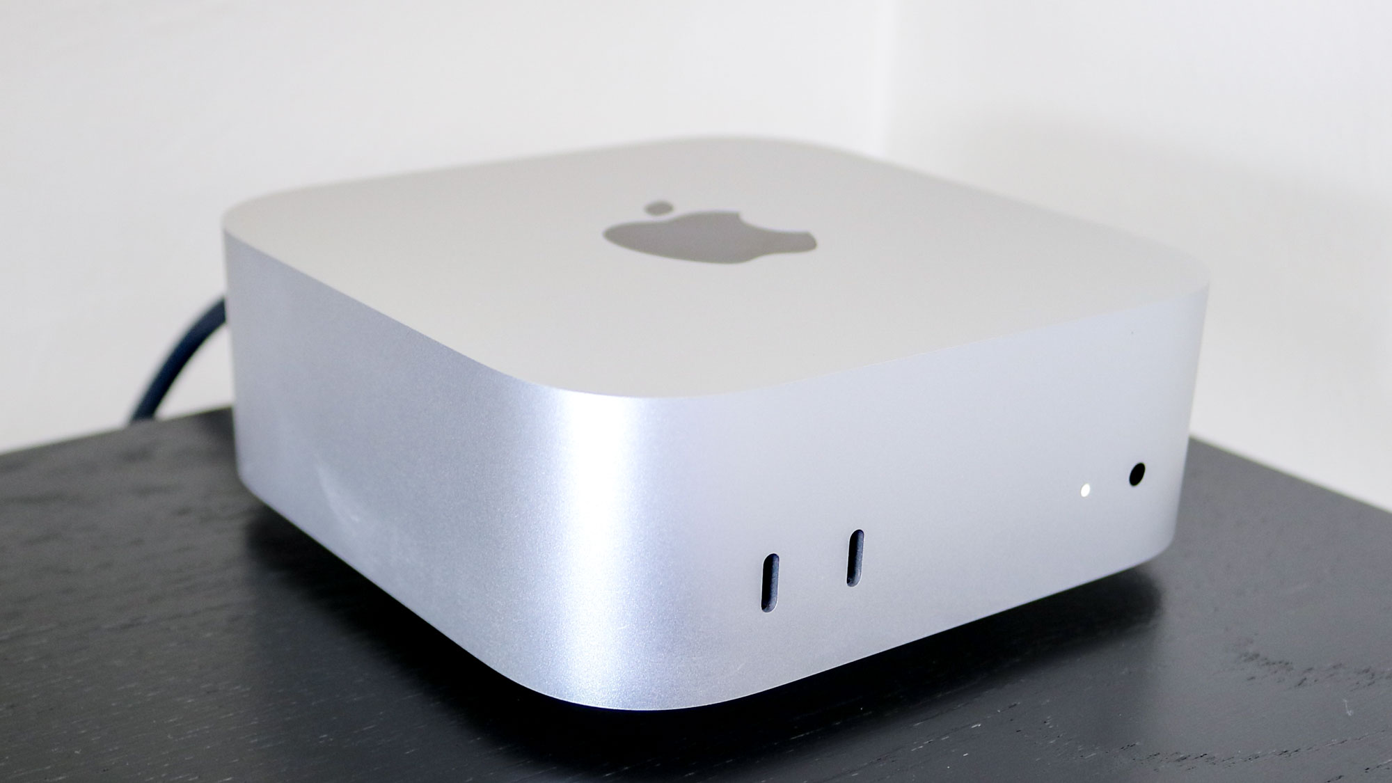 جهاز Mac mini M4 موضوع على رف مرتفع للمكتب
