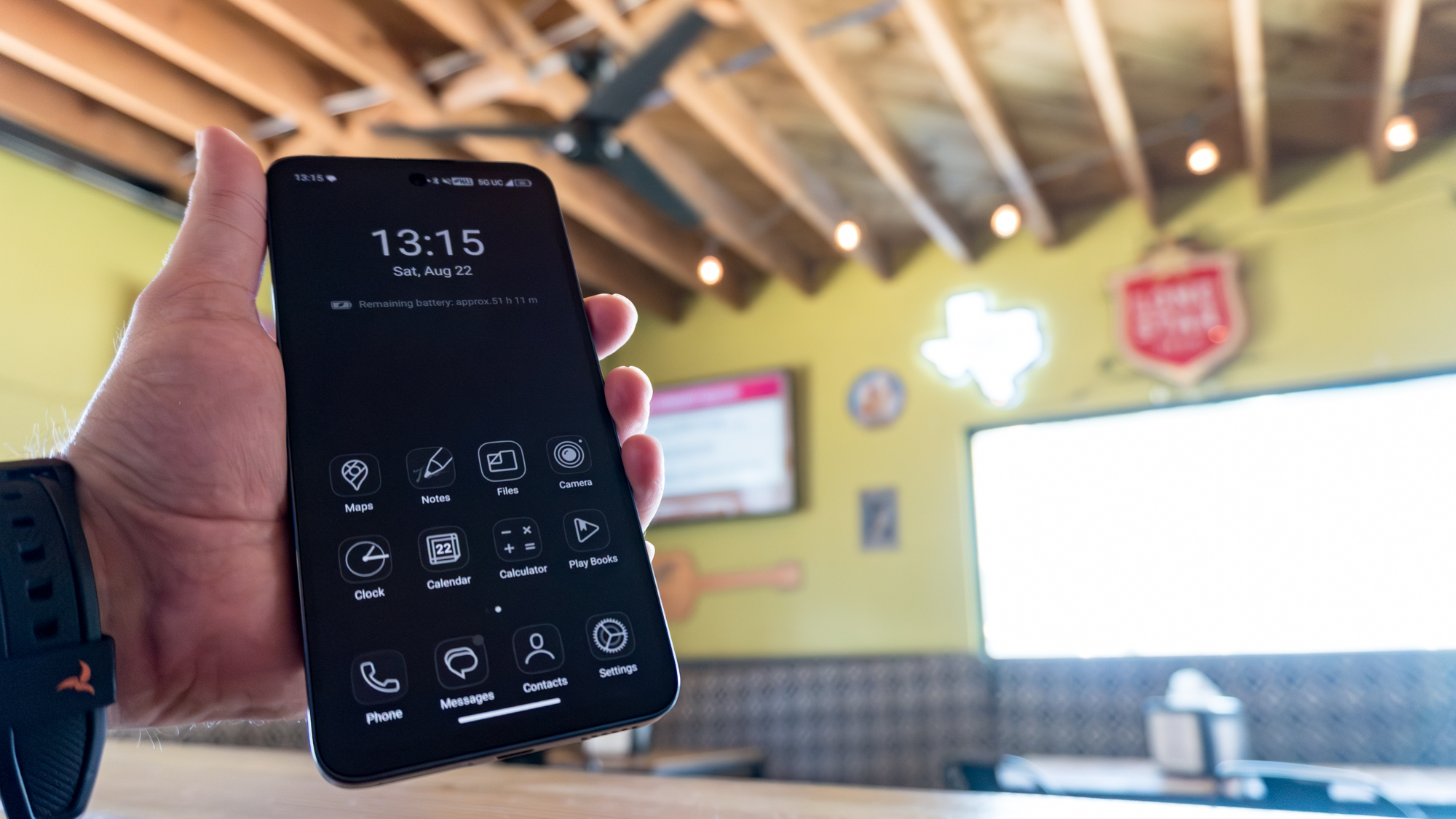 شخص يمسك هاتف TCL NXTPAPER 70 Pro والجهاز في وضع Max Ink Mode داخل مطعم