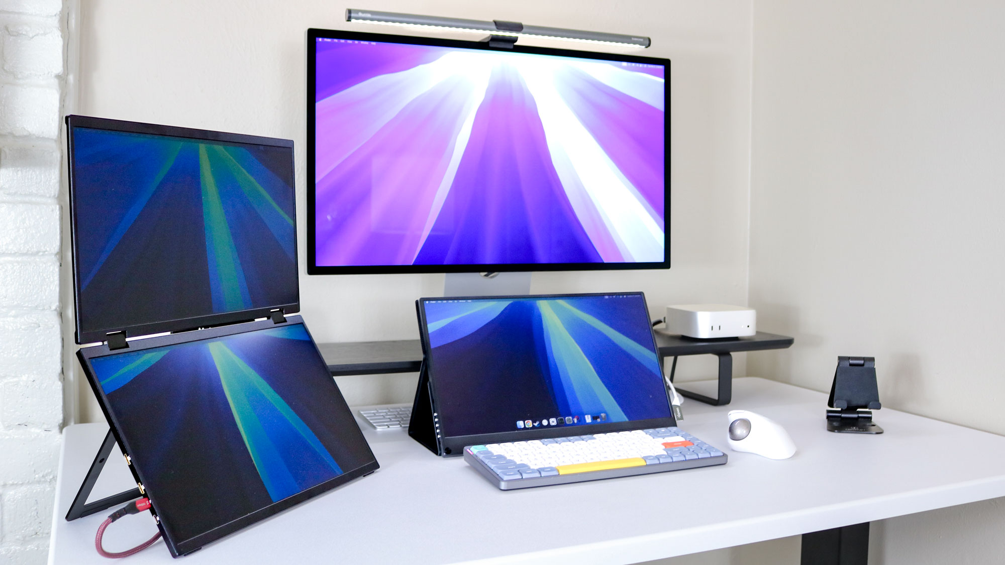 إعداد ثلاثي الشاشات يعمل بواسطة جهاز Mac mini M4
