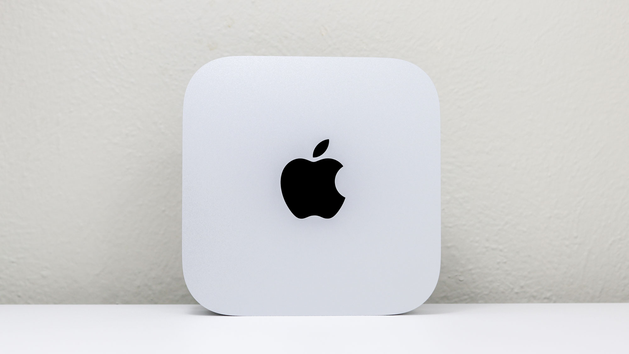 جهاز Mac mini M4 منتصبًا على مكتب يظهر شعار Apple