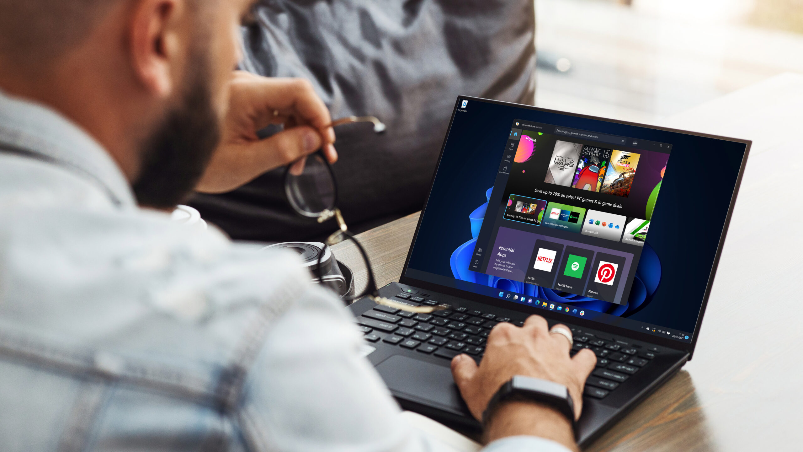 منظر خلفي لرجل يستخدم لابتوب مع تطبيق Microsoft Store مفتوح على Windows 11