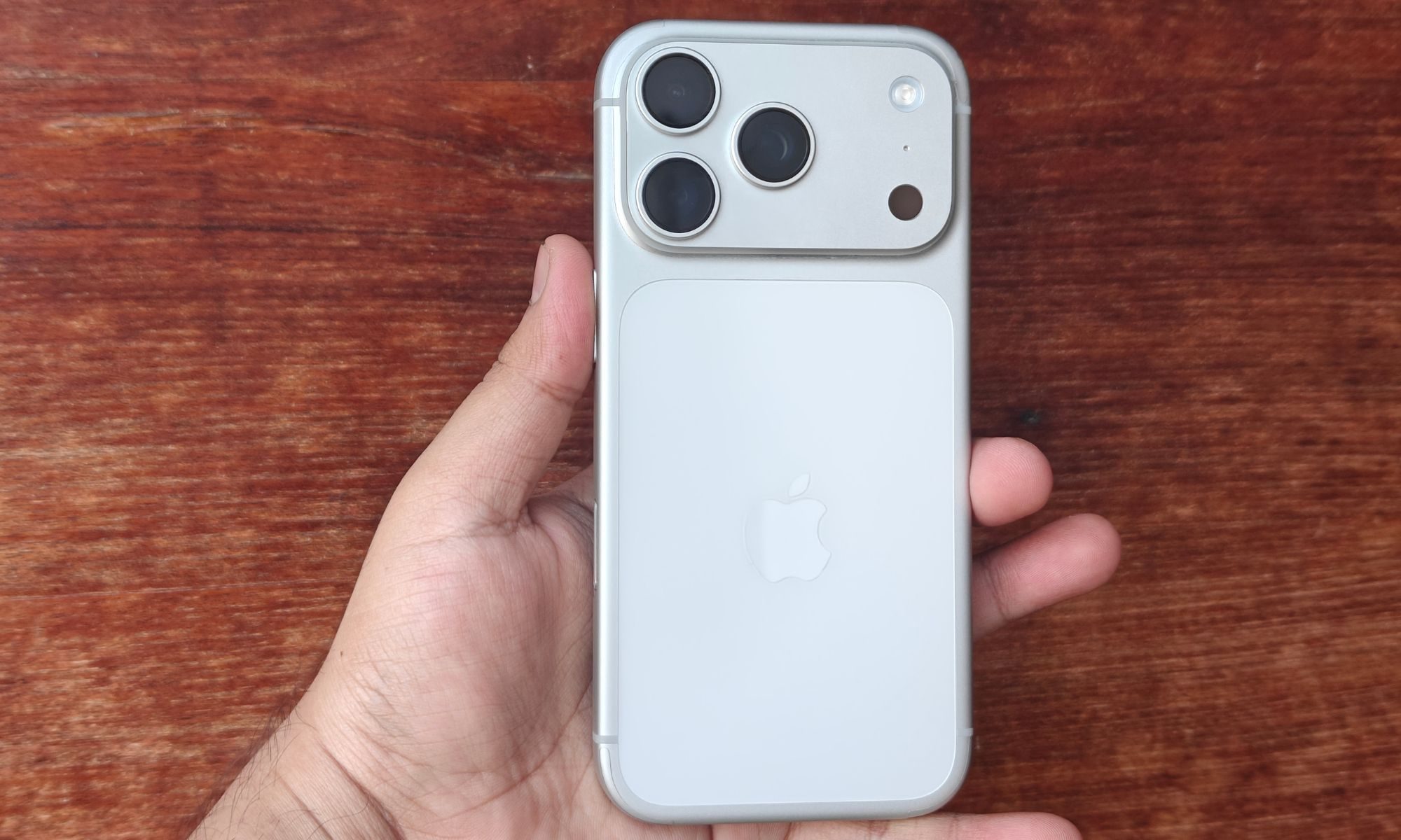 يد تحمل هاتف iPhone 17 Pro.