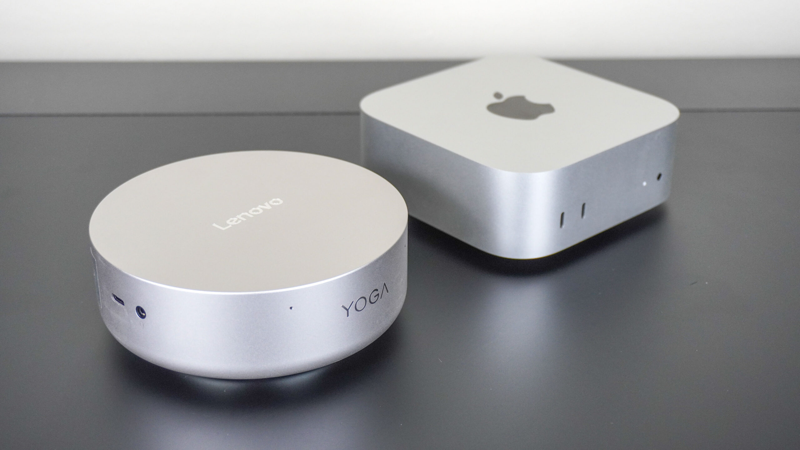 جهاز Lenovo Yoga Mini بجوار Apple Mac mini M4 على مكتب