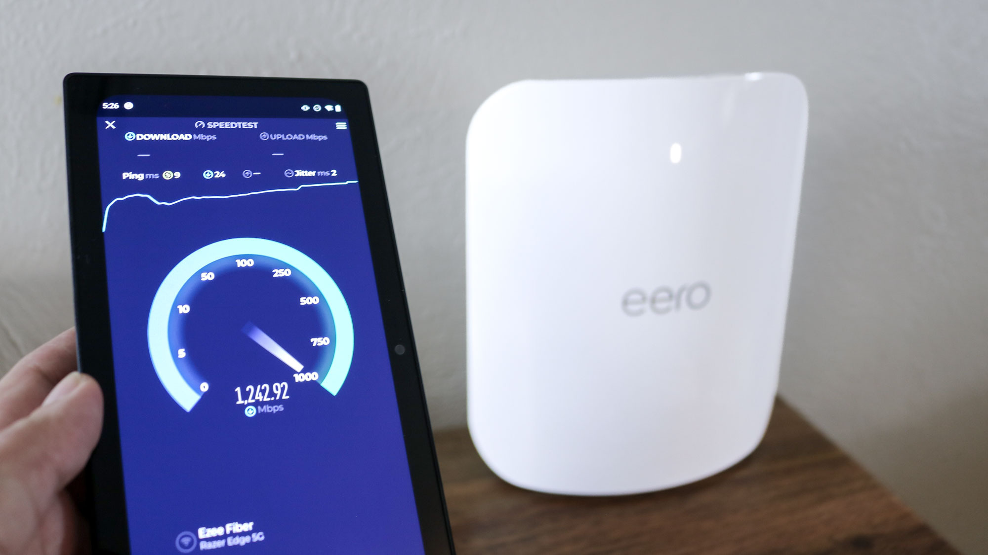 هاتف يجري اختبار سرعة بجوار راوتر eero Max 7 الشبكي