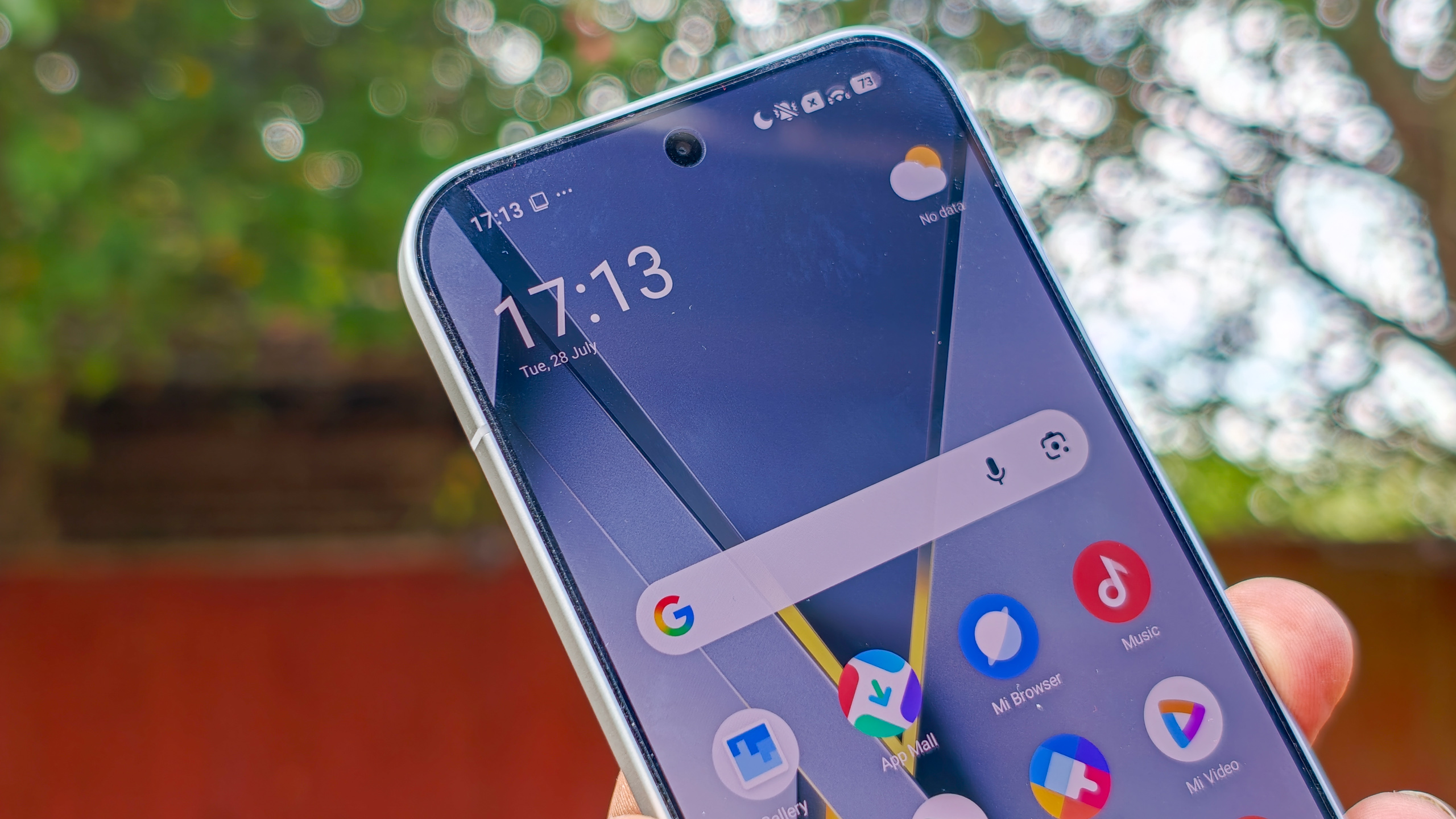 هاتف Poco F8 Pro باللون الفضي في اليد بخلفية حديقة