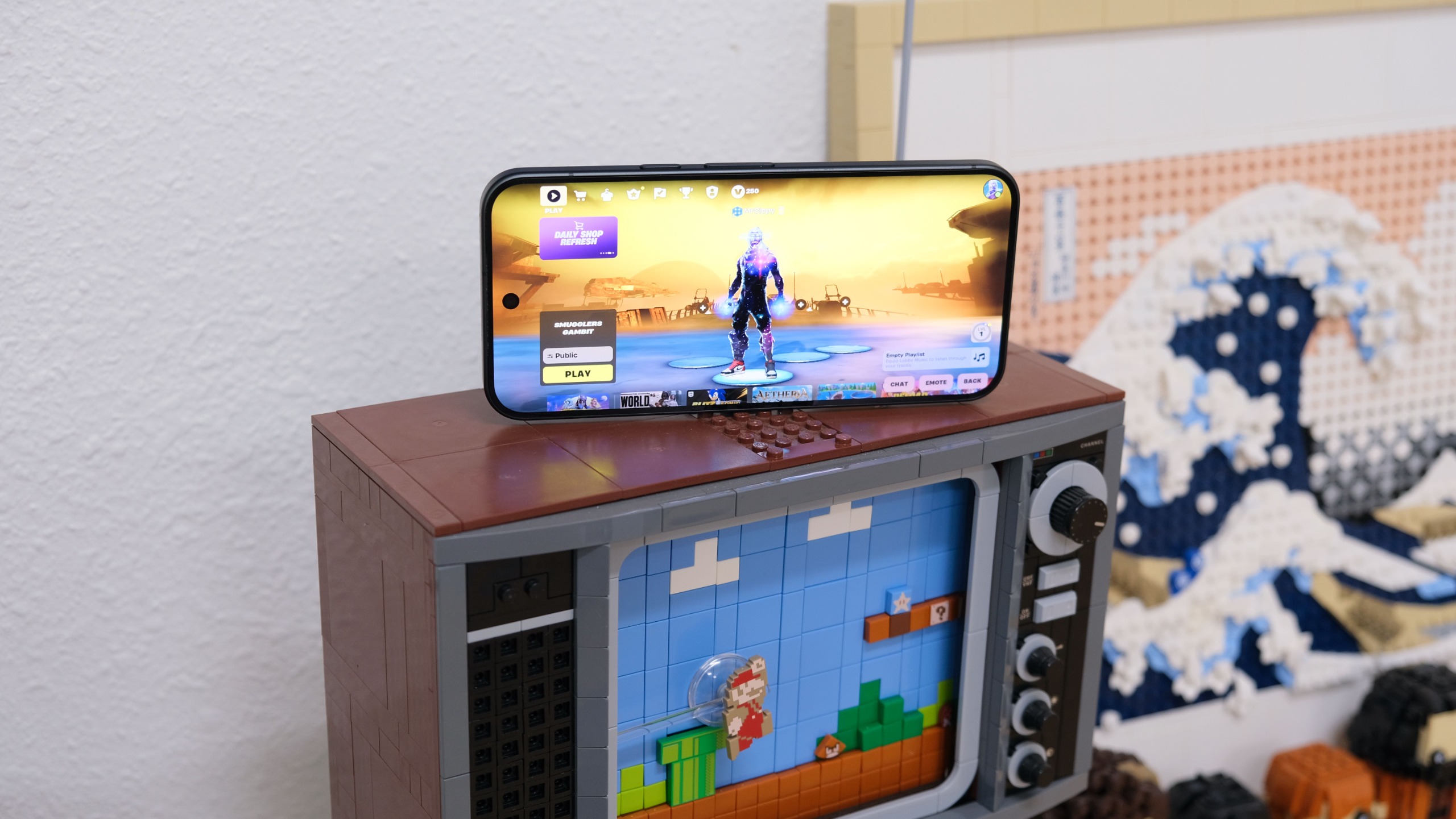 هاتف Google Pixel 11 Pro XL يعرض لعبة Fortnite وهو يستقر على مجموعة تلفزيون من Lego